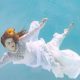 a woman in a white dress underwater.